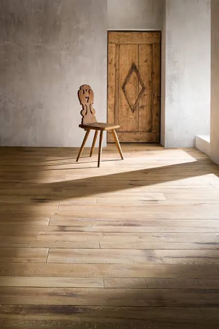 Helle Dielen in einem Raum mit Holzstuhl und Holztür